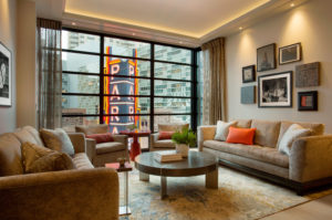 Transitional living space, gallery wall, soffit ceiling, soft accent lighting, recessed lighting, wallwashers, black window muntins, statement windows, city view, modern living space, Boston