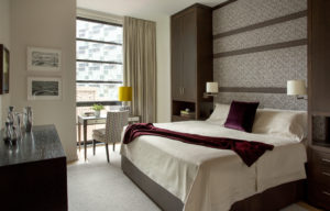Custom millwork, upholstered headboard, statement wall, accent wall, built-in storage, full height storage cabinets, fabric wall panels, wall mounted headboard, transitional bedroom