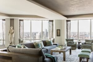 Transitional living toom, window wall, large sculpture, ceiling soffit, textured ceiling, window seat, upholsetred window bench, sectional, sofa console, grey, green, turquoise, open concept