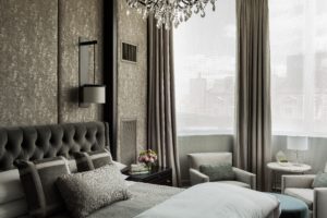 Dramatic, custom upholstered wall panels, upholstered headboard, glam, crystal chandelier, velvet, custom millwork, luxurious master bedroom, transitonal master bedroom, dark wood panels, espresso, gray, cream