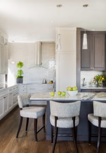 White kitchen, city kitchen, transitional kitchen, white subway tile, contemporary hood, shaker cabintets, counter height chairs, breakfast bar, marble counter