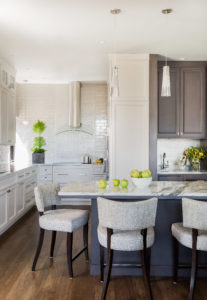 White kitchen, city kitchen, transitional kitchen, white subway tile, contemporary hood, shaker cabintets, counter height chairs, breakfast bar, marble counter