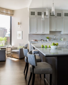 White kitchen, city kitchen, transitional kitchen, white subway tile, contemporary hood, shaker cabintets, counter height chairs, breakfast bar, marble counter