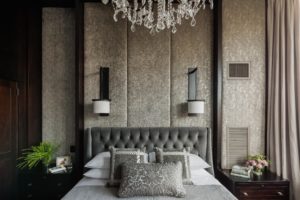 Dramatic, custom upholstered wall panels, upholstered headboard, glam, crystal chandelier, velvet, custom millwork, luxurious master bedroom, transitonal master bedroom, dark wood panels, espresso, gray, cream