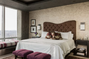 Textured wallpaper, dark ceiling, soffit, window bench, upholstered headboard, burgandy, maroon, contemporary wall sconces, bedroom, picture window, sheer curtains, chaise lounge, stripes, martini table, city view, transitional bedroom