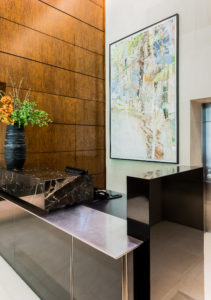 Commecial project, concierge desk, contemporary wood paneled wall, marble, black marble, asymmetrical desk, geometric, abstract art
