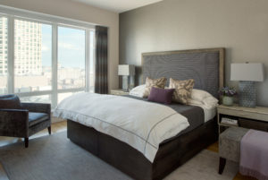 Transitional bedroom, master bedroom, modern, contemporary, upholstered headboard, city view, tonal, elegant, platform bed, purple, white duvet, wallpaper, accent wall