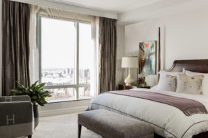 Trasnitonal bedroom, two-post bed, 2 post bed, end of bed bench, custom drapery, silk drapery, white duvet, purple accent color, white bedroom walls, soffit