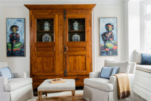 transitional living room, transitonal family room, window seat, window seat cushion, neutral color palatte living room, blue and white living room, antique cabinet, antique hutch, modern art
