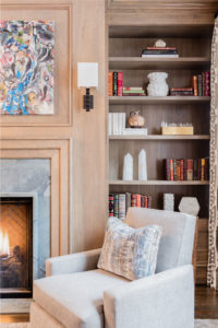 transitional study, transitional den, living room, wood paneled walls, wood paneling, fireplace surround, applied moulding, custom millwork, built in bookcase, abstract art