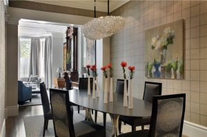 grid wallpaper,textured walls,statement wallpaper,crystal chandelier,modern chandelier,formal dining room,upholstered dining chair,tall bud vases,oval dining table modern