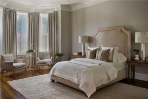 upholstered headboard,mercury glass light,mercury glass table lamp,bay window,elegant bedroom,monochromatic bedroom,tonal,oversized crown moulding,gray walls,taupe