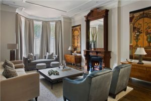 Wood fireplace surround,velvet armchairs,velvet upholstery,blue velvet,modern low profile coffee table,large coffee table,tet a tet,bay window
