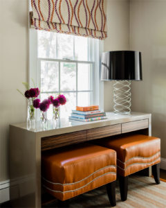 waterfall edge console table,nailhead trim,orange ottomans,unique table lamp,black lamp shade,high gloss lacquer console,lacquer console table