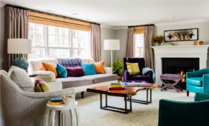 aqua,blue leather arm chair,bright pillows,colorful,live edge coffee table,nailhead trim,orange,ottoman,purple,wood burning fireplace