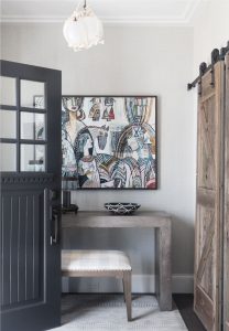 Interior barn door, rustic wood console table, abstract art, cubist painting, transitional entry foyer, modern rustic design, upholstered bench, charcoal gray entry door,
