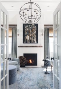 Transtional living room, caged iron chandelier,light grey upholstery,monochromatic color scheme,reclaimed wood moulding,rustic wood details, cubist artwork, abstract painting