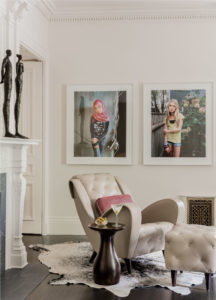 transitinal accent table, contemporary brass sculpture, cowhide rug, crown moulding,leather armchair,modern art,modern photography,transitional living room