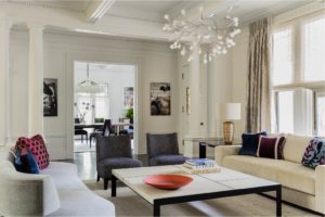 animal print chair,applied moulding,arched doorways,contemporary living room,high ceilings,red velvet chair,statement color,tray ceiling,white walls