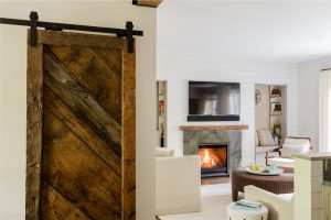interior barn door, reclaimed wood barn door, transtional family room, stone fireplace surround, reading nook, wall niche, built in book cases, custom millwork