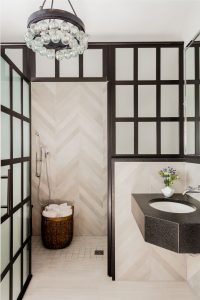 herringbone tile pattern, herringbone wall tile, large format tile design, walk in shower, contemporary chandelier, wall mounted faucet, transitional bathroom