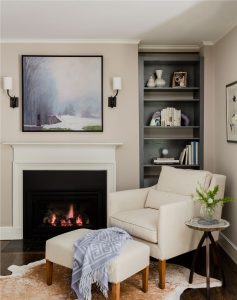 master bedroom sitting area, master bedroom fireplace, bookshelf niche, built in bookcase, transitional master bedroom, transitional fireplace surround, neutral color palette, cowhide rug