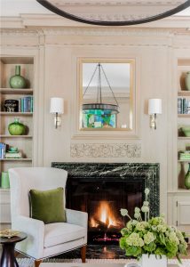 transitional living room, wall niche, built in bookcase, wood burning fireplace, transtional fireplace surround, contemporary chandelier, aged iron chandelier, transitional chandelier, applied wall moulding, transitional wall sconces, green marble fireplace surround