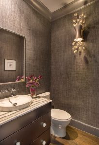 black bathroom vanity,decorative sconce,grasscloth wallpaper,gray crown molding,textured wallpaper,transitional bathroom,oversized crown