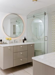 Contemporary Bath, Master Bath, Contemporary Master Bath, Limestone and gold inlays, floating vanity, round mirror illuminated from behind, sliding glass shower door, onyx marble vanity top