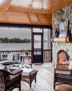 Lakehouse, modern rustic lakehouse, screened porch, sunroom, three season room, stone fireplace, woodburning stone fireplace, wicker furniture, wood paneled ceiling, transitional patio furniture, contemporary outdoor sofa, indoor outdoor furniture