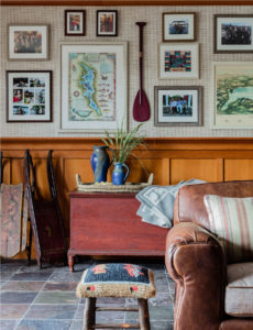 Modern rustic game room, transitional game room design, lakehouse, wood paneling, stained wainscotting, leather sofa, slate floor tiles, antiques