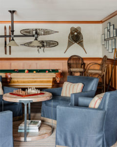 Modern rustic game room, transitional game room design, lakehouse, wood paneling, stained wainscotting, leather sofa, slate floor tiles, antiques