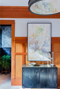 transitional lakehouse, modern rustic sideboard, transitional buffet, wood paneled walls, transitional chandelier, abstract art, oversized contemporary art