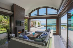 contemporary poolhouse, ocean view living room, two story fireplace, contemporary fireplace surround, transtional scetional sofa, in ground pool, transitional family room