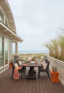 transitional outdoor furniture, ocean view deck, orange accent table, outdoor dining table, beach house design