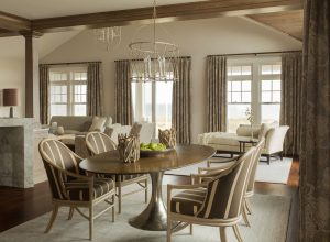 Narrow oval dining table, metal base dining table, transitional dining room,transitional living room, open living space, living and dining room, open conceptm stained wood beams, custom drapery, transitional chandelier, chaise lounge
