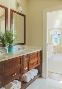 transitional bathroom design, custom bathroom millwork, white bathroom floor tile, dark wood bathroom vanity, his and her sink, dual bathroom vanity with storage, beach house bathroom