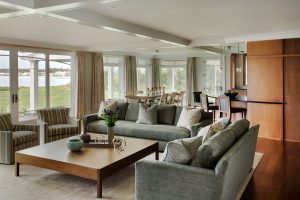 transitional family room,large coffee table,low coffee table,open floor plan,shared living and dining space,square coffee table,wood paneling