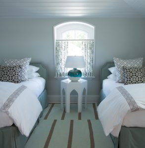 transitional guest bedroom, beach house twim bedroom, demilune window, geometric side table, turquoise blue lamp base, seafoam green area rug