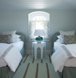 transitional guest bedroom, beach house twim bedroom, demilune window, geometric side table, turquoise blue lamp base, seafoam green area rug