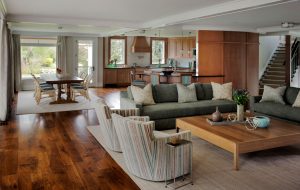 curved wall,family room,large coffee table,low coffee table,open floor plan,shared living and dining space,square coffee table,wood paneling