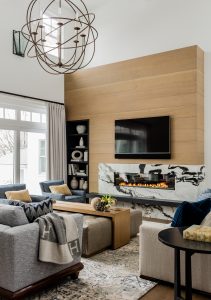 fireplace, modern fireplace, black and white fireplace, sherical chandelier, astronomy chandelier, round chandelier, Saturn chandelier, fireplace wall, wall tv, recessed shelving, sconce, transistional furnihsings, ottoman cocktail table