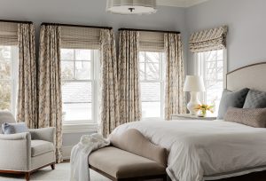 master bedroom, curtain panels, roman shade, woven wood shades, woven shades, white table lamp, white shade, upholstered headboard, bedding, white duvet, decorative pillows, bed pillows, small lounge chair, petite bench, upholstered bench, end of bed bench, neutral tones, tranquil colors, area bed, ceiling light