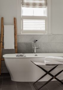modern bath, minimalist bath, tile floor, white tub, cafe shutter, roman shade,