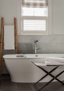 modern bath, minimalist bath, tile floor, white tub, cafe shutter, roman shade,