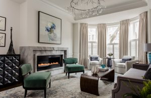 modern art, abstract art, fireplace, modern fireplace, modern chandelier, bay windows, floor to ceiling drapery, living room, area rug, wainscotting, chair rail, round side table, modern sofa, sculpture