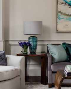 blue lamp, glass lamo, blue accents, side table, wainscotting, chair rail, modern sofa